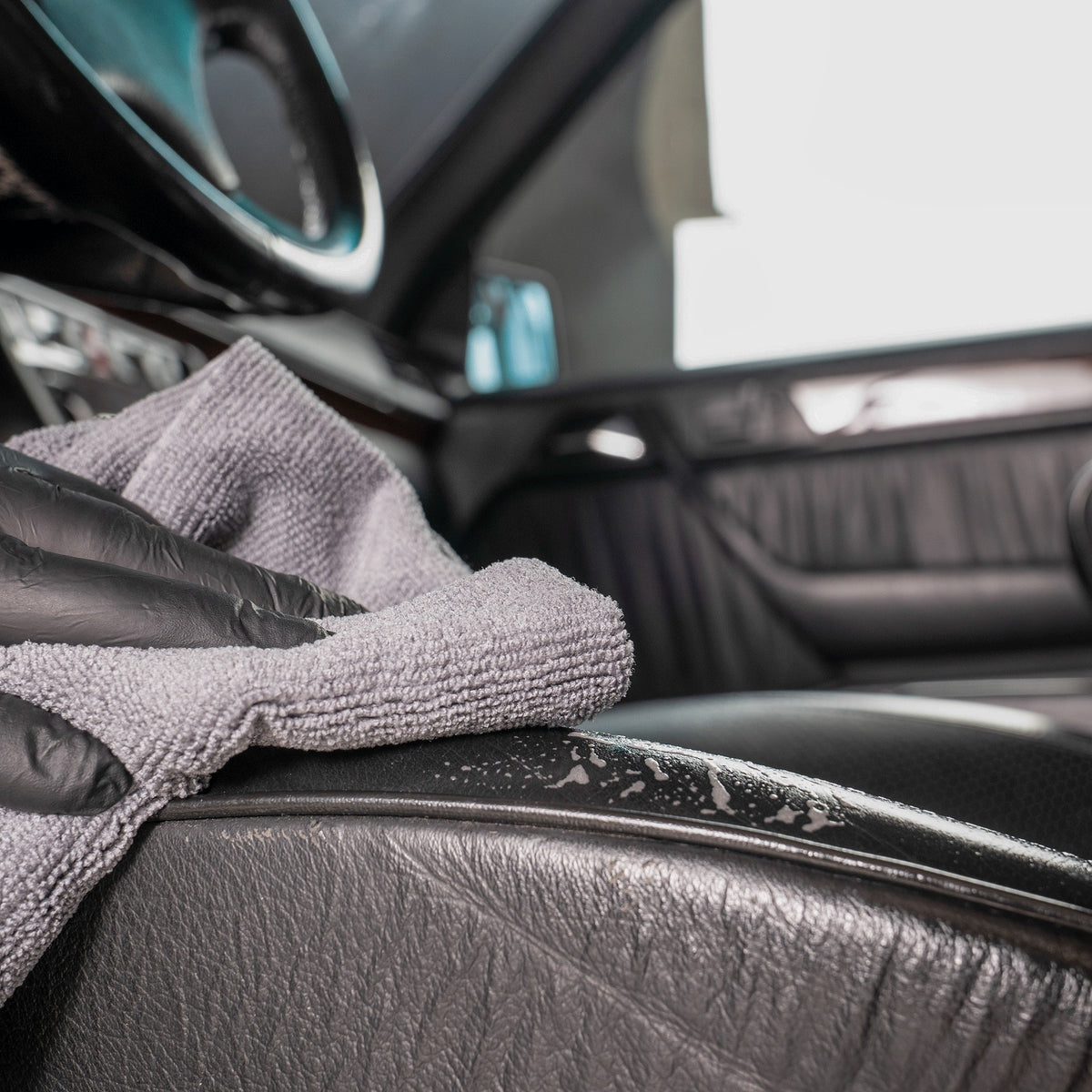 Detailing1 COLOURLOCK Leather Cleaner (Mild) — passata finale in microfibra sul fianchetto in pelle nera
