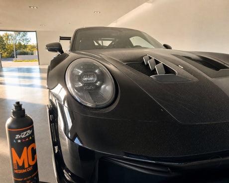 Detailing1 ZviZZer MC 3000 Medium Cut One-Step-Politur 750 ml vor Swirls im Streiflicht auf schwarzem Porsche-Lack