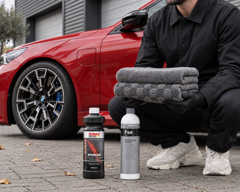 Detailing1 set asciugatura — panno Aqua, Koch-Chemie Pro Drying Towel, SONAX HyperCoat e Fse accanto alla BMW M5 rossa