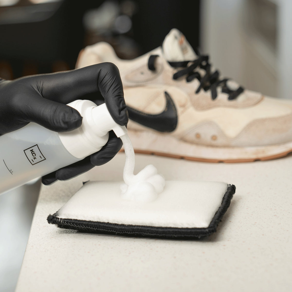 Detailing1 COLOURLOCK Sneaker Cleaner — schiuma detergente sul pad, dietro la sneaker sporca